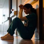 burnout nurse sitting in hallway
