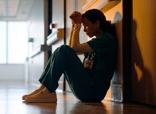 burnout nurse sitting in hallway
