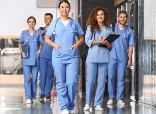 A group of nursing students walk in a hospital hallway.