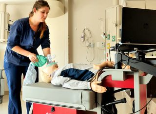 Healthcare provider practice CPR on a manikin.