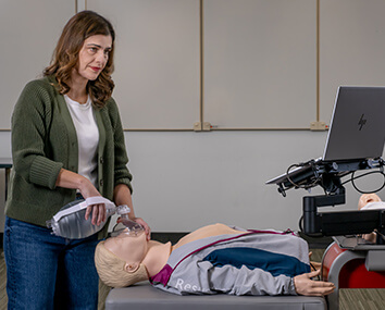 Person completing CPR training using a manikin and laptop