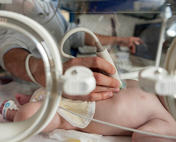 Doctor with newborn in neonatal intensive care Doctor with newborn in neonatal intensive care